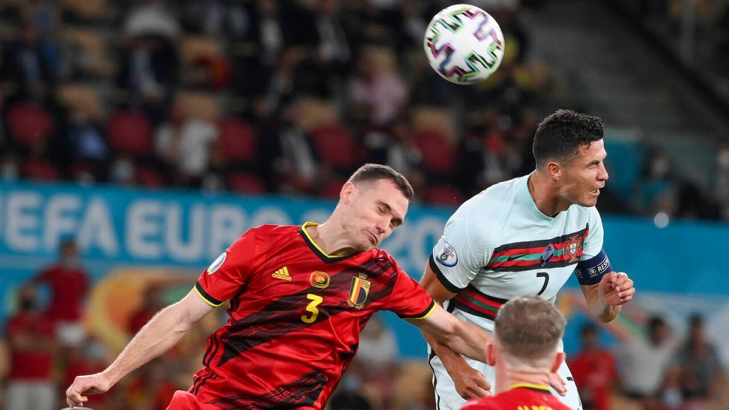 O português Cristiano Ronaldo (à direita) e o belga Thomas Vermaelen competem para cabecear a bola